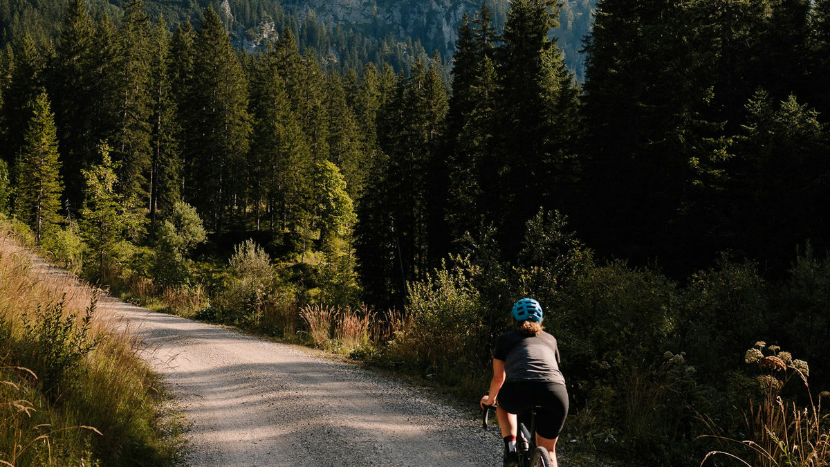 Cyclist riding a gravel bike down a dirt road