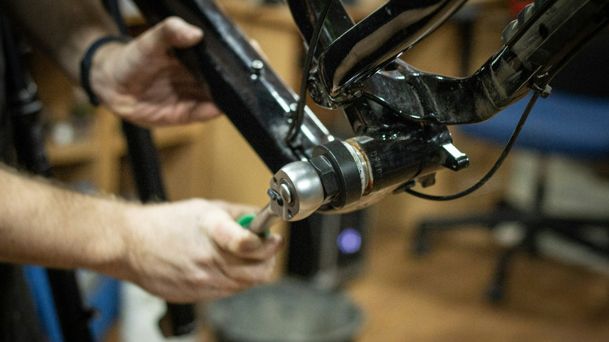 Close-up of hands working on a bicycle