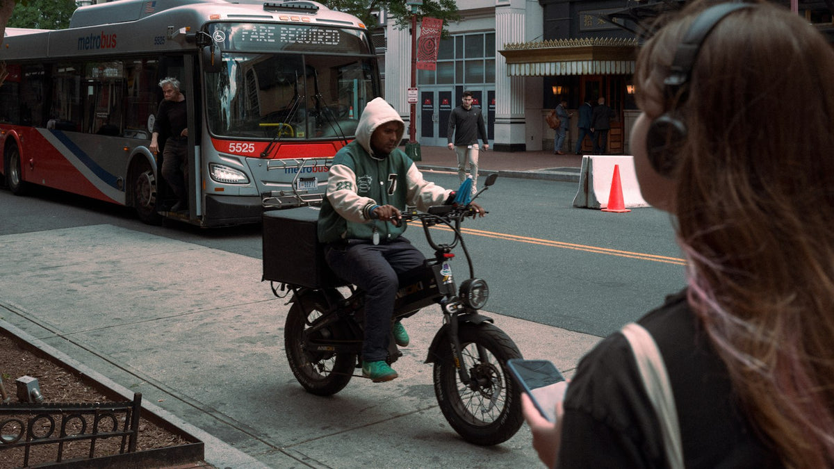 E-bike delivery rider passing a city bus
